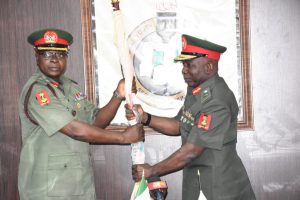 Former NYSC Director-General, Maj.-Gen. Suleiman Kazaure (Right) hands over NYSC Flag to Newly Appointed NYSC Director-General, Brig.-Gen. Shuaibu Ibrahim (Left) as he officially assumes office