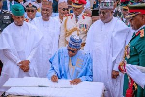 Osinbajo, Senate President Ahmed Lawan watch as Buhari signs the Independence Day register