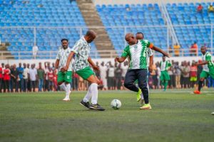 Governor Yahaya Bello tackles one of the players during the novelty match