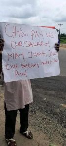 One of the workers with his placard protesting over the unpaid salaries