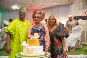 Mr and Mrs Bayo Onanuga with their daughter Tobi during the cutting of the cake