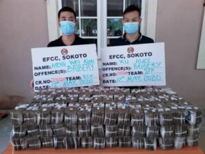 Chinese nationals Meng Wei Kun and Xu Kuai: docked for alleged attempt to bribe EFCC official with N50 million in Sokoto, Nigeria ( Pictured with them is the alleged bribe money)