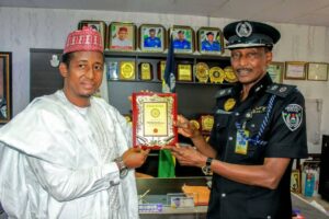 Commissioner for Land receiving souvenir from CP Gumel during the visit at Bomapai Police headquarters