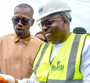 Governor Siminalayi Fubara putting on PPE while Commissioner for Works, Alabo George Kelly watches during the flag off of Elelenwo Internal Roads on Thursday
