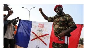 Supporters of Niger’s National Council of Safeguard of the Homeland (CNSP) display a French national flag with a x-mark on during a protest outside Niger and French airbase in Niamey on September 1, 2023 to demand the departure of the French army from Niger. (Photo by – / AFP)