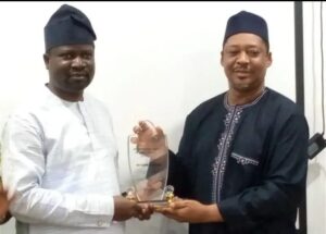 The state commissioner for Finance, Budget and Planning, Asiru Idris, receiving the award from Tijani Abdulkareem