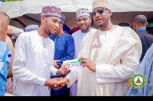 Governor Radda handing over cheque to a beneficiary