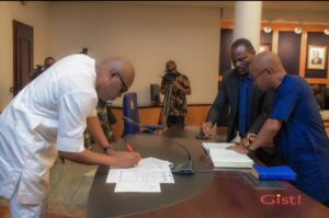 Left to right: Governor Siminalayi Fubara and Joseph Johnson,(in blue) newly sworn in Commissioner for Information and Communications signing his oath of office.