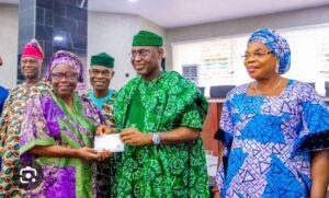 Gov Oyebanji presenting one of the cheques to a beneficiary