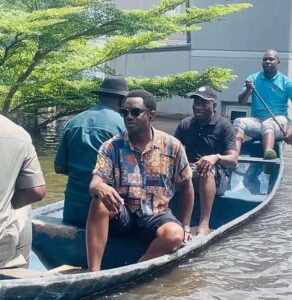 Former President Jonathan(in baseball cap) is paddled on flood water_ Image courtesy of Google