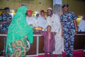 Governor Yusuf handing over the sum of N500, 000 to one of the abducted victims and his mother, as CP Gumel watches on in high spirit
