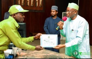 One of the Corps members receiving his certificate from Governor Namadi