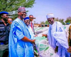 Gov. Sule hands a bag of fertilizer to a farmer