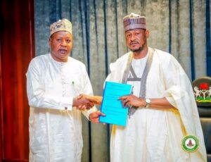 Governor Dikko Umaru Radda receiving the report from Alhaji Tukur Ahmed Jikamshi