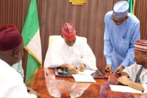 Governor Yusuf while signing the premarital health screening bill into law