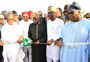 CAPTIONS Pic 19. President Bola Tinubu () cutting the tape to officially Flag-off the construction of Lagos-Calabar Coastal Highway in Lagos on Sunday (26/5/2024). With him are from left: Minister of Works, Sen Dave Umahi; Gov Hope Uzodimma of Imo State; Gov Babajide Sanwo-Olu of Lagos State and the President of the Senate, Godswill Akpabio