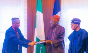 President Tinubu receiving the report from Professor Larry Awosika, a marine scientist and member of the Committee, and Surveyor Aliyu Omar, Secretary of the HPPC