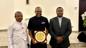Mayor of Housing (middle) flanked by Hon Enitoun Ezekiel Iyala (l) and Rev/Dr Joseph Joseph (r) with a plaque as a Patron and an honorary membership of the Choir