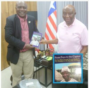 President Joseph Boakai of Liberia, right, presenting his book to Abubakar Hashim of TheNEWS in Monrovia.jpg
