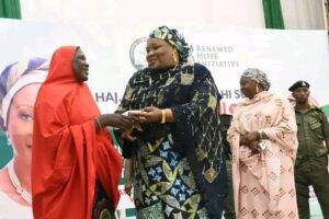 Hajia Selifat Abdullahi Sule handover money to a beneficiary.jpg