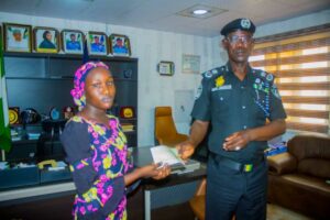 CP Dogo handing over a cheque to one of the beneficiaries.jpg
