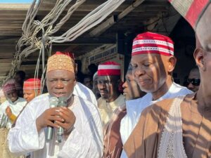 Governor Yusuf and leader of the market during his visit to Kantin Kwari texrile market on Thursday.jpg