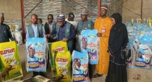Muhuyi with his officials sampling the diverted bags of FG palliative rice intercepted in a warehouse in Kano.jpg