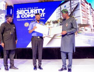 Lagos state Governor, Mr. Babajide Sanwo-Olu (right) presenting a certificate to the Inspector General of Police, Mr. Kayode Egbetokun while the Special Adviser to the Governor on e-GIS and Urban Development, Mr. Olajide Babatunde (left) watches, during the groundbreaking of 2,200 Police Housing units at Ijeh Barracks, Ikoyi, on Thursday, December 19, 2024