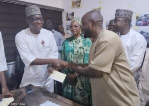 Deputy Governor, Joel Salifu Oyibo presenting the cheques to the victims
