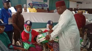 Waiya handing over a gift to a spinal cord victim during the event