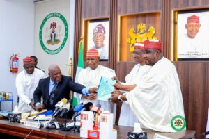 Governor Yusuf and his Deputy displaying the Kano State Security Neighborhood Watch law (2025)