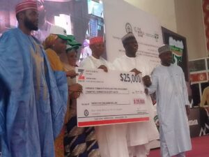 Governor Yusuf issuing the cheque to one of the beneficiaries