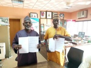 Jigawa SSG (left) displaying the MoU with one of the private security outfit representative in his office