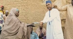 Aide of the Deputy Senate President handing over the money to one of the victim's wife