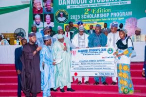 One of the beneficiaries receiving a cheque of N300, 000 from Governor Namadi