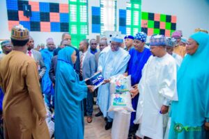 Governor Namadi receiving a pack of Tom Brown from one of the trainees during the graduation ceremony