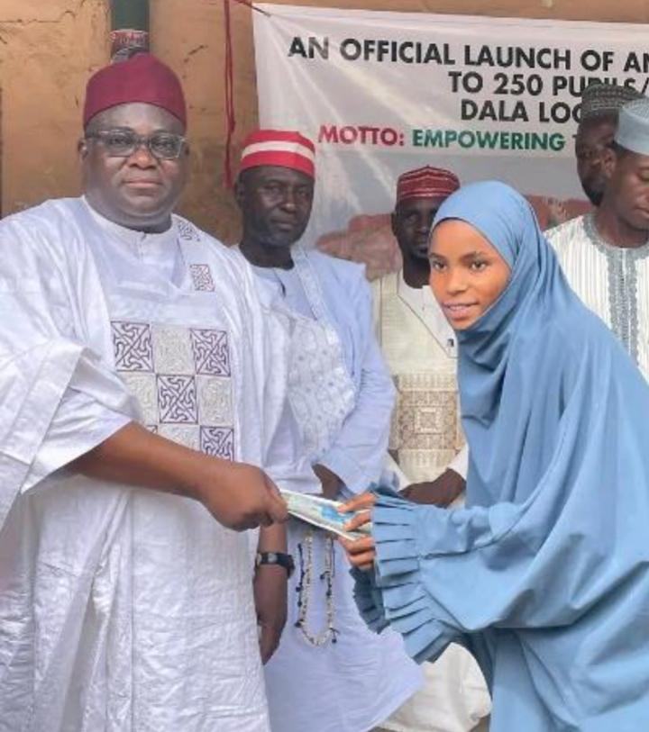 Waiya handing over education materials to one of the beneficiaries