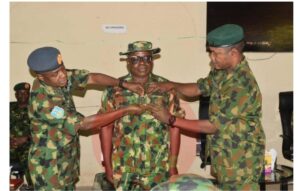 Major General Warrah Idris and another senior officer, decorating one of the beneficiaries