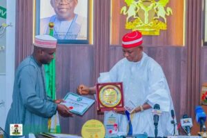 Sunusi Bature handing over some of the Awards to Governor Yusuf during the Council meeting