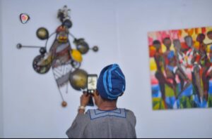 A guest taking a photograph of one of the art works at the exhibition