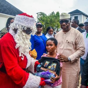 Senator Opeyemi Bamidele and one of the children Christmas gift beneficiaries