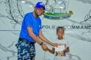 Kano state Commissioner of Police, Mr. Bakori delivering a cheque to one of the beneficiaries