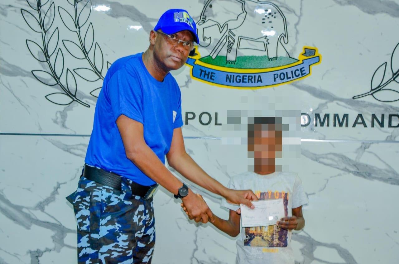 Kano state Commissioner of Police, Mr. Bakori delivering a cheque to one of the beneficiaries