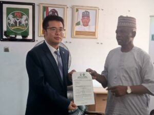 Permanent Secretary of the Ministry of Works and Transport, Engr. Sagir Abdulsalam, presenting the certificate to the Project Manager of CCC Construction Company, Mr. Austin Qi