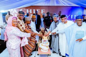 Pa Reuben Fasotranti cutting his centenary birthday cake, assisted by Shettima, Aiyedatiwa, Abiodun, Mimko, Fayemi