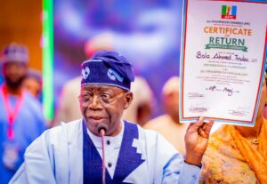 President Tinubu displaying his ceritificate of return